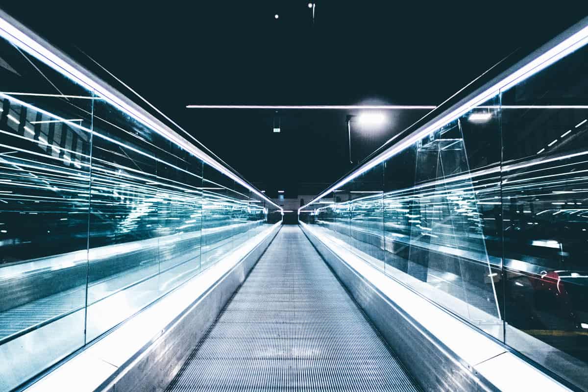 Nighttime view down a glass-railed escalator