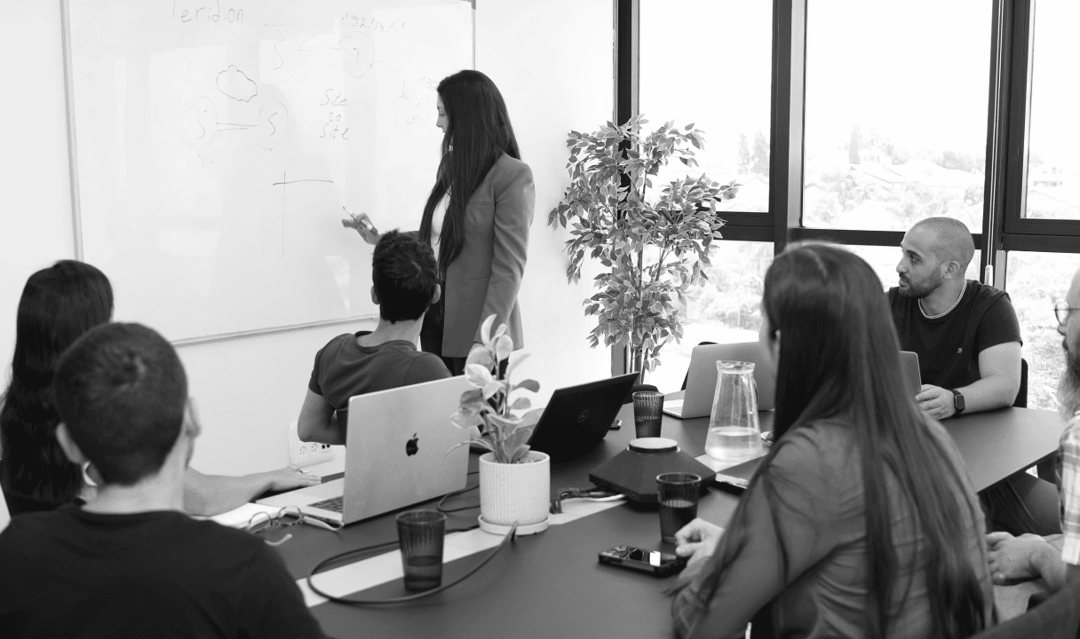 Woman at table explaining sustainable cost reduction strategies for IT leaders